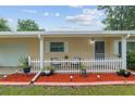 Welcoming front porch with charming white picket fence and colorful landscaping, perfect for relaxing outdoors at 9940 Sw 101St Pl, Ocala, FL 34481