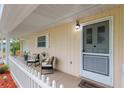 Inviting front porch featuring cozy seating and a welcoming entrance, perfect for enjoying the outdoors at 9940 Sw 101St Pl, Ocala, FL 34481