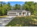 Beautiful single-story home with a well-maintained lawn, neutral paint, and two-car garage at 14540 Se 33Rd Ter, Summerfield, FL 34491