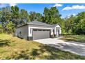 Attractive home showcasing a two-car garage, neutral colors, and landscaped front yard at 14540 Se 33Rd Ter, Summerfield, FL 34491