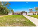 Single-story home with grey exterior, fenced yard, and well-maintained landscaping at 16220 Sw 19Th Avenue Rd, Ocala, FL 34473