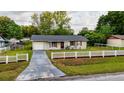 Inviting single-Gathering home with a driveway, grassy lawn, and a charming white picket fence at 2140 Ne 40Th St, Ocala, FL 34479