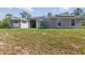 Beautiful one-story home showcasing a manicured front yard, large windows, and lovely curb appeal at 22189 Sw Neptune Blvd, Dunnellon, FL 34431