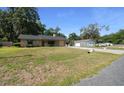 Spacious front yard showcases a single-story brick home with an extended driveway leading to a detached garage at 2576 Ne 34Th St, Ocala, FL 34479