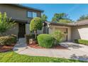 Charming exterior view of a townhome with well-manicured bushes and a single-car garage and driveway at 3815 Ne 17Th Street Cir, Ocala, FL 34470