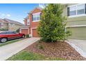 Two-story townhome with a single-car garage and mature landscaping in front at 4927 Sw 45Th Cir, Ocala, FL 34474