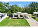 Single-story home with a well-manicured lawn, carport, and lovely landscaping at 518 Saint Andrews Blvd, Lady Lake, FL 32159