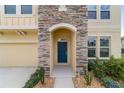 Close up of a home's front entrance with a stone archway and a blue front door at 5653 Sw 50Th Ter, Ocala, FL 34474