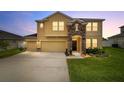 Charming two-story home featuring a stone-accented entrance, well-manicured front yard, and three-car garage at 5653 Sw 50Th Ter, Ocala, FL 34474