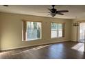 Inviting living room with wood floors, large windows, and a stylish ceiling fan at 616 Water Rd, Ocala, FL 34472