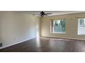 Bright living room featuring new flooring, a ceiling fan, and natural light from large windows at 616 Water Rd, Ocala, FL 34472