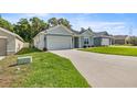 Well-maintained single-story home with an attached garage and lush green lawn at 6557 Se 4Th Ln, Ocala, FL 34472