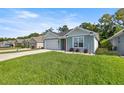 Charming single-story home with a well-manicured lawn and attached garage at 6557 Se 4Th Ln, Ocala, FL 34472