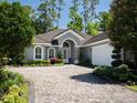 A beautiful single-story home with arched windows, a tile roof, and a paved driveway at 8033 Nw 29Th Street Rd, Ocala, FL 34482