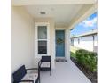 Cozy front porch with seating, a decorated blue front door, and tasteful landscaping at 8820 Sw 58Th Street Rd, Ocala, FL 34481