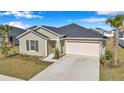 Well-kept single-story home showcasing an attached two-car garage and a simple, landscaped front yard under a bright sky at 9266 Sw 58Th Cir, Ocala, FL 34476