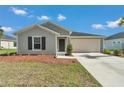 Single-story home featuring a two-car garage, front yard landscaping, and a neutral exterior at 9266 Sw 58Th Cir, Ocala, FL 34476