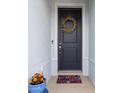 Inviting front entrance with a dark door, wreath, and colorful potted flowers at 9459 Sw 52Nd Loop, Ocala, FL 34481
