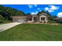 Lovely one-story home with manicured lawn, stone details, and an attached garage at 11586 Sw 75Th Cir, Ocala, FL 34476