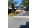 Charming single-story home with a bright sunroom, landscaped yard, and paved driveway at 1408 Torrey Pines Dr, Lady Lake, FL 32159