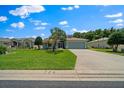Beautiful one-story home featuring manicured lawn and a concrete driveway leading to a garage at 16193 Sw 14Th Avenue Rd, Ocala, FL 34473