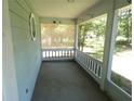 A covered and screened in front porch with railings, offering a comfortable outdoor space at 19026 Sw 100Th Pl, Dunnellon, FL 34432