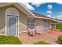 Charming front entrance with pink chairs on a tile patio and a well-lit doorway at 21 Pine Trace Run, Ocala, FL 34472