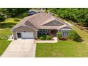 Charming exterior of home featuring a well-manicured lawn and attached two-car garage at 465 Ne 155Th Street Rd, Citra, FL 32113