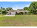 Inviting front exterior of a home with a large lawn, two car garage and mature landscaping at 465 Ne 155Th Street Rd, Citra, FL 32113