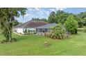 Lush backyard featuring a large, screened-in lanai and mature trees at 5661 Nw 96Th Ln, Ocala, FL 34482