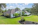 Well-manicured lawn with charming single-story home with fresh landscaping and a welcoming walkway at 5661 Nw 96Th Ln, Ocala, FL 34482