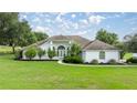 Charming single-story home with a pristine lawn, mature landscaping, and a welcoming entrance at 5661 Nw 96Th Ln, Ocala, FL 34482
