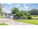 View of outbuilding with grey siding, white trim, and tidy landscaping at 5661 Nw 96Th Ln, Ocala, FL 34482