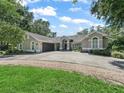 Charming single-story home with attached garage and circular driveway surrounded by mature trees and landscaping at 5714 Nw 80Th Avenue Rd, Ocala, FL 34482