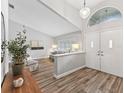Bright foyer featuring wood-look tile floors, a half wall, and a view into the living room with natural light at 5714 Nw 80Th Avenue Rd, Ocala, FL 34482