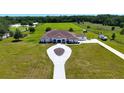 Expansive property featuring a stunning white home, extensive green spaces, and equestrian facilities at 6160 W Highway 326, Ocala, FL 34482