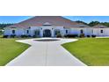 A beautiful white home with a circular driveway and lush green lawn, perfect for outdoor enjoyment at 6160 W Highway 326, Ocala, FL 34482