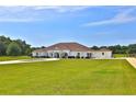 Expansive single-story home featuring a sprawling lawn and elegant facade at 6160 W Highway 326, Ocala, FL 34482