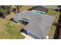 Aerial view of the house showcasing a pool with screened-in enclosure and well-manicured landscaping at 6211 Se 126Th St, Belleview, FL 34420