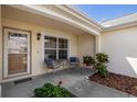 Inviting front porch area with seating and a 'Blessed' welcome mat at 8352 Se 168Th Trinity Pl, The Villages, FL 32162