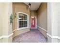 Inviting front porch with brick flooring, elegant door, and stylish wall-mounted light fixture at 8650 Sw 83Rd Loop, Ocala, FL 34481