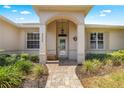 Inviting front porch with decorative columns, brick pathway and lush landscaping at 9628 Sw 90Th St, Ocala, FL 34481