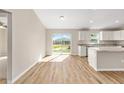 Eat-in kitchen featuring wood flooring and sliding glass door at 10124 Sw 130Th Ct, Dunnellon, FL 34432