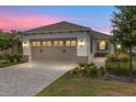 Charming single-story home featuring a two-car garage, well-maintained landscaping, and a welcoming entrance at dusk at 10427 Sw 98Th Place Rd, Ocala, FL 34481