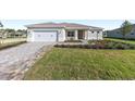 Attractive single-story home with manicured lawn, a paver driveway, and an inviting front entrance at 10569 Sw 98Th Pl, Ocala, FL 34481