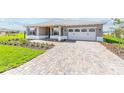Beautiful single-story home with a brick paver driveway and lush green lawn at 10977 Sw 101St Loop, Ocala, FL 34481