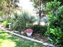 Lush backyard landscaping featuring colorful plants and charming garden decorations at 13762 Sw 112Th Ter, Dunnellon, FL 34432