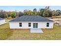 View of the backyard showing a grey patio extending from the sliding glass doors at 17010 Sw 44 Cir, Ocala, FL 34473