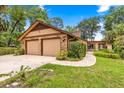 Spacious two-car garage with an adjacent brick-paved walkway and verdant landscaping at 2416 Se 15Th St, Ocala, FL 34471
