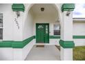 Inviting front entrance featuring a vibrant green door, textured columns, and a welcoming ambiance at 2521 Nw 45Th Pl, Ocala, FL 34475
